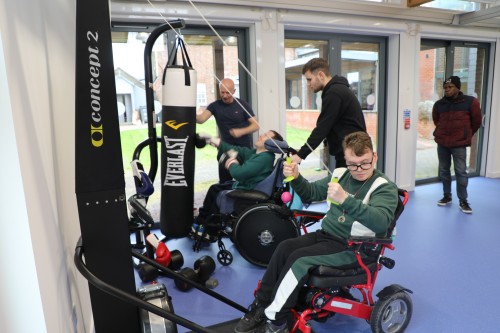 Young man in a wheelchair using the gym equipment